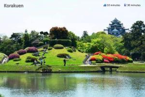 a garden with flowers and a pond and a building at 東横のヨコ in Okayama