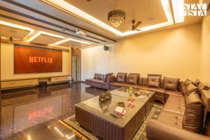 a living room with a couch and a television at StayVista at The Binclave with Jacuzzi, Pvt Indoor Pool, Bar & Projector in Jaipur