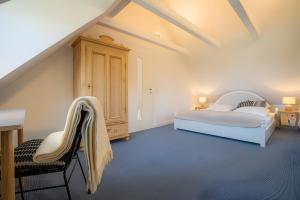a bedroom with two beds and a table and chairs at Landhaus Sommerland in Uelvesbüll