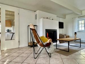 a living room with a chair and a table at Landhaus Sommerland in Uelvesbüll +21 photos