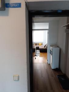 an open door to a living room with a couch at Apartman Bulevar Živinice in Živinice