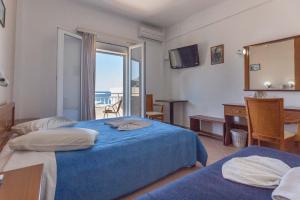 a hotel room with two beds and a mirror at Ξενοδοχείο Βεργίνα in Oikonomiánika