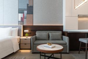 a hotel room with a bed and a couch and a table at Wanda Jin Xiaohe Xincheng in Taiyuan