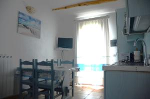 a kitchen with a table and chairs and a window at Casa vista mare in San Teodoro +7 photos