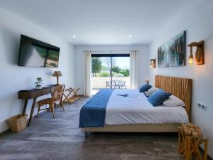 a bedroom with a bed and a desk and a window at Hotel Fazio in Bonifacio