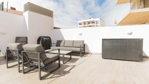 a patio with chairs and a table on a building at Orange Boutique Residence - Casa Farol in Quarteira +2 photos