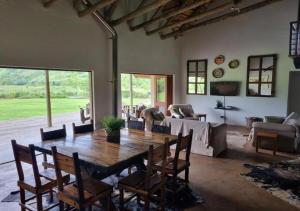 a living room with a wooden table and chairs at Plain Champagne Guest Farm, Champagne Valley in Winterton