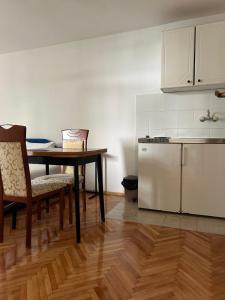 a kitchen with a table and a refrigerator at Apartments and Room MV in Petrovac na Moru