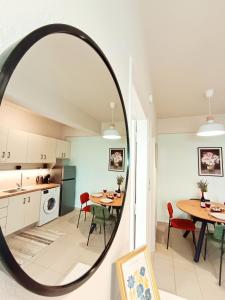 a kitchen and dining room with a round mirror at Elounda Solo Apartment in Elounda