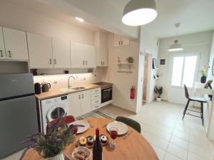 a kitchen with a table and a kitchen with white cabinets at Elounda Solo Apartment in Elounda +20 photos