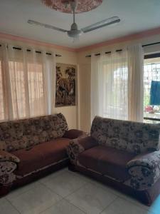 a living room with a couch and windows at aphyl homes in Mombasa +1 photo