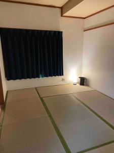 a room with mats in front of a black curtain at 2-minute walk to the sea, a secret base that children can also enjoy, beautiful high-ceiling beams, free gas BBQ rental, detached villa in Kujukuri +31 photos