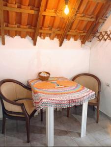 a table with two chairs and a table cloth on it at Chalezinho da Serra in Natividade da Serra