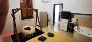 a bathroom with a hammock and a tub and a room with a television at dolce roma in Civitavecchia