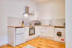 a kitchen with white cabinets and a washer and dryer at Superb City Center 2 Bed Apartment Free Wifi in Lincoln +5 photos