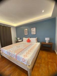 ein Schlafzimmer mit einem großen Bett mit einer blauen Wand in der Unterkunft Apoheo Beach Cabin Free Use Motorbike During Stay in El Nido