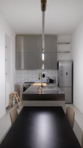 een keuken met een tafel en een roestvrijstalen koelkast bij The WEST NEST in Zagreb