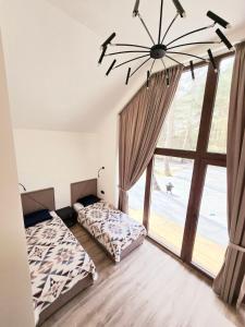 a bedroom with two beds and a large window at Lazy House Latvia in Jūrmalciems