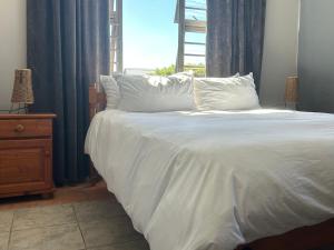 a bedroom with a white bed with a window at Riverside Sunday's in Colchester