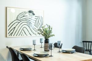 a dining room table with black chairs and a vase with flowers at Oskar Apartments in Neustift im Stubaital