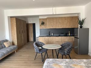 a kitchen and a living room with a table and chairs at Fusion Apartment in Dobra Voda