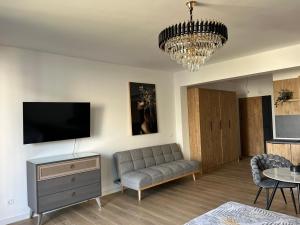 a living room with a couch and a flat screen tv at Fusion Apartment in Dobra Voda