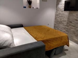a bedroom with a bed with a brown blanket on it at Old Town Baska in Baška