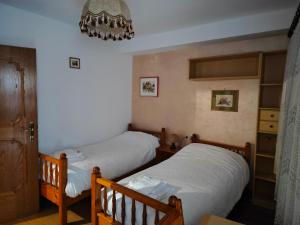 two twin beds in a bedroom with a chandelier at Casa Rizzi in Campitello di Fassa