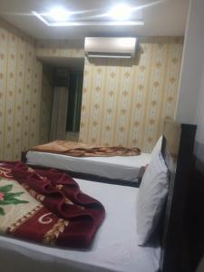 two beds in a small room with a mirror at Star Residency Hotel in Islamabad +21 photos