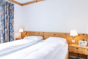 Postel nebo postele na pokoji v ubytování Hotel Chesa Grischa
