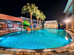a swimming pool at a hotel at night at บ้านสวนชมจันทร์ กำแพงแสน in Ban Song Hong