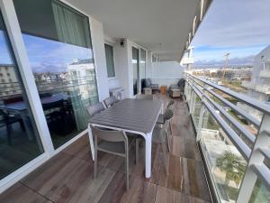 a dining room with a table and chairs on a balcony at Palm Beach Jesolo in Lido di Jesolo