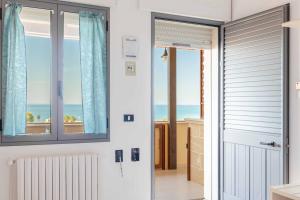 a door to a room with a view of the ocean at Hotel La Collinetta in Torre Vado