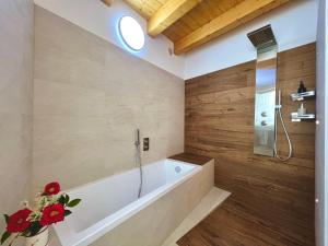 a bath tub in a bathroom with wooden walls at Sogno Blu - Levico in Levico Terme +29 photos