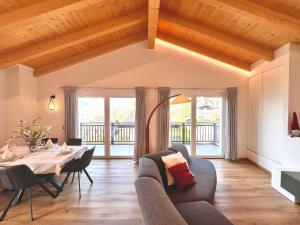a living room with a table and a couch at Sogno Blu - Levico in Levico Terme