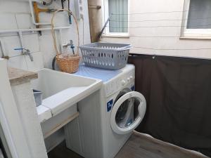 a washing machine and a sink in a tiny house at Cozy and sunny penthouse Fira BCN in Hospitalet de Llobregat
