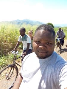a man posing for a picture with people on bikes at Mount Mulanje Stopover in Peremwe