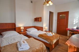 a hotel room with two beds and a table at Willa Dąbrówka in Szczawno-Zdrój