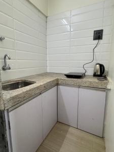 a small kitchen with a sink and a microwave at Meluha Motels in Navi Mumbai