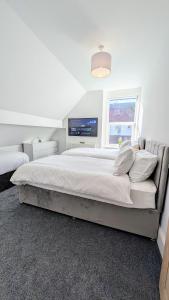 a bedroom with a large bed with a tv on the wall at Llandudno Lounge by Seaside Llandudno in Llandudno