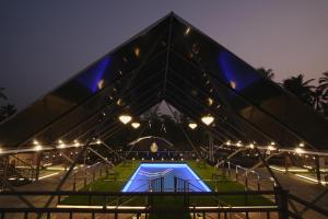 a pyramid shaped building with a swimming pool at night at Parlak in Karuvapadna