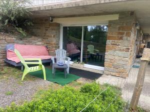 a patio with chairs and a couch and a table at Studio à la campagne in Cordemais