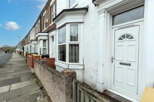 una fila de casas con puertas blancas en una calle en Pensbury House, en Darlington