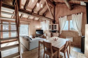 a living room with a table and a couch at Romantic Chalet in the Leventina Mountains by Quokka 360 - Romantic Chalet in Faido