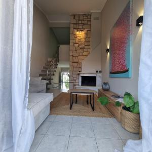 a living room with a table and a fireplace at Vaios Luxury Apartments Polichrono in Polykhrono