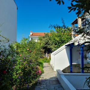 a walkway in a garden with flowers and a building at Vaios Luxury Apartments Polichrono in Polykhrono +5 photos