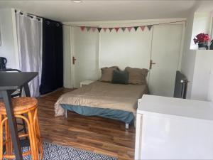 a small bedroom with a bed and a desk at Studio à la campagne in Cordemais