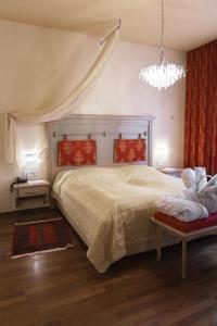 een slaapkamer met een groot bed en een kroonluchter bij Hotel Paradiesquelle 4 in Puchberg am Schneeberg