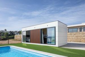 una casa con una piscina di fronte di Complejo Bungalow con piscina a A Pobra do Caramiñal
