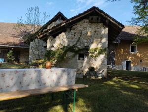 a bench sitting in front of a stone building at Charmante maison de famille rustique à la campagne in Groslée